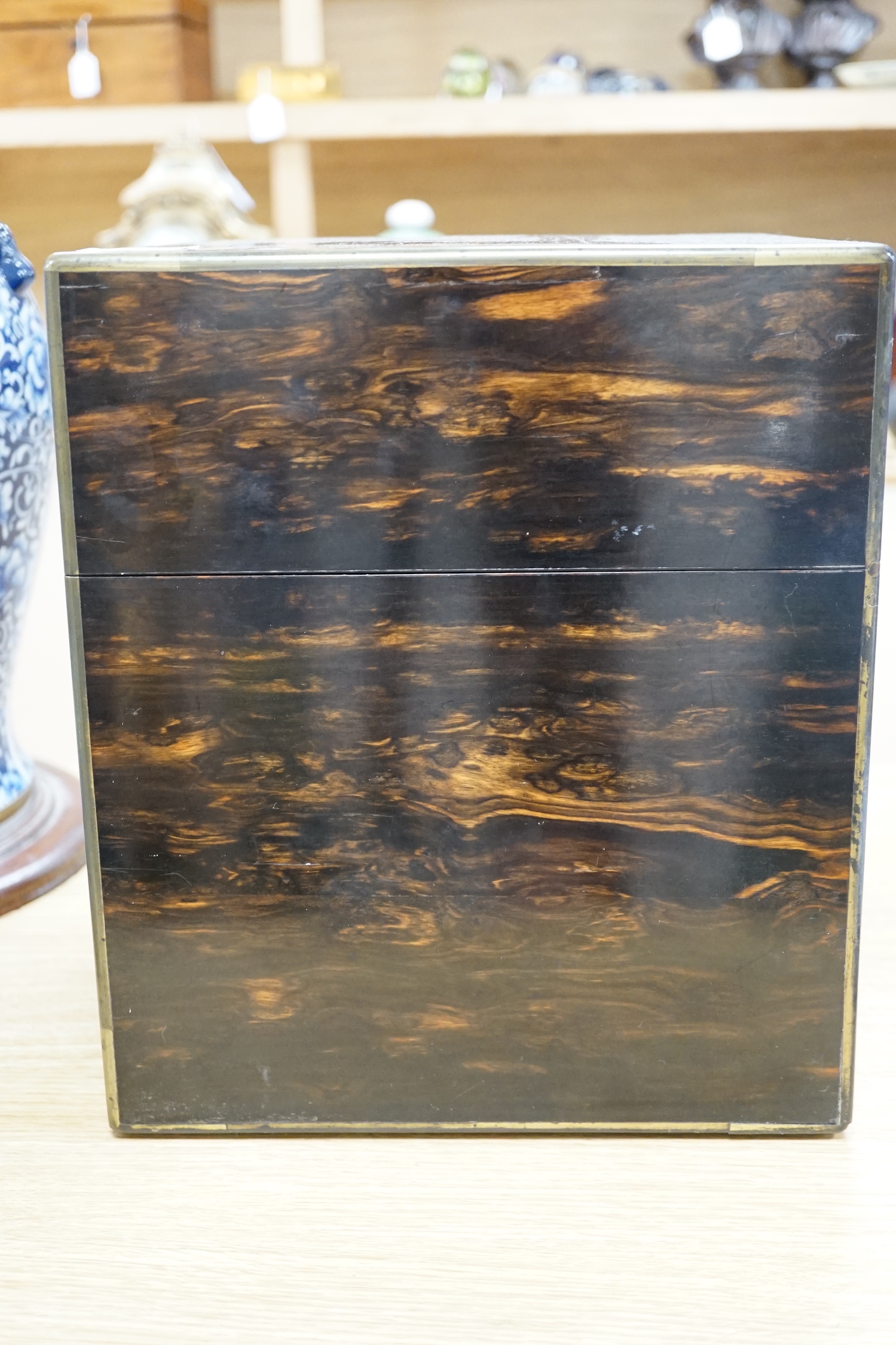 A Victorian coromandel four bottle decanter box with Bramah lock, three silver ‘hunting’ spirit labels and another enamelled, height of box 30cm